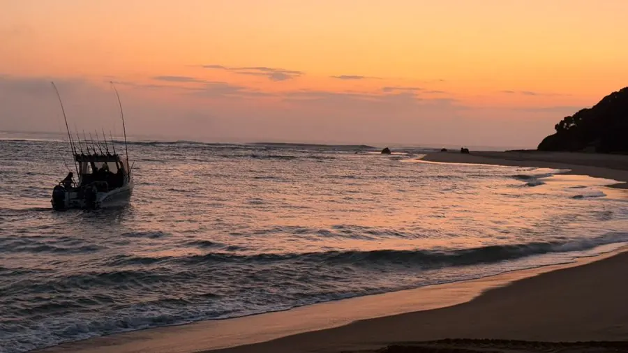 Ski-boat launching through the shore break at sunrise